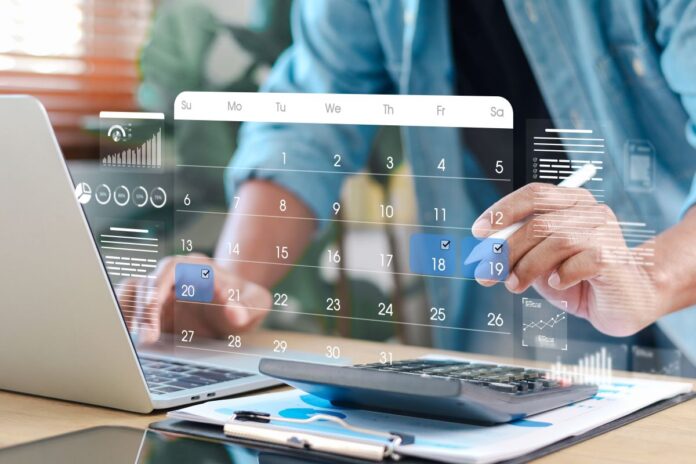 Businessman planning schedule and financial tasks using digital calendar interface on laptop. Concept of time management, accounting, budgeting, and productivity.